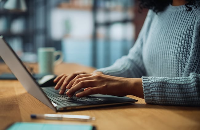 Hands typing on a laptop